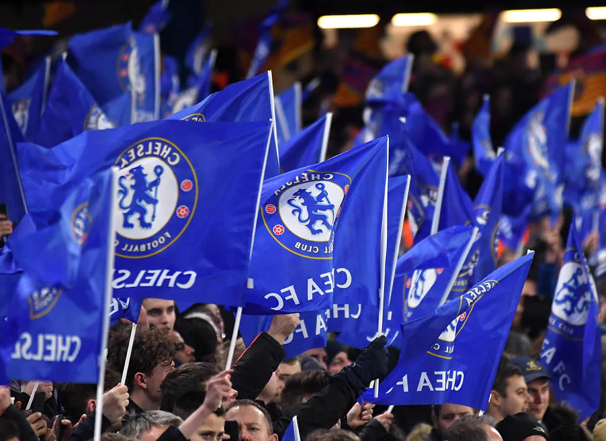 Chelsea-supportrar viftar med blå flaggor med klubbmärket