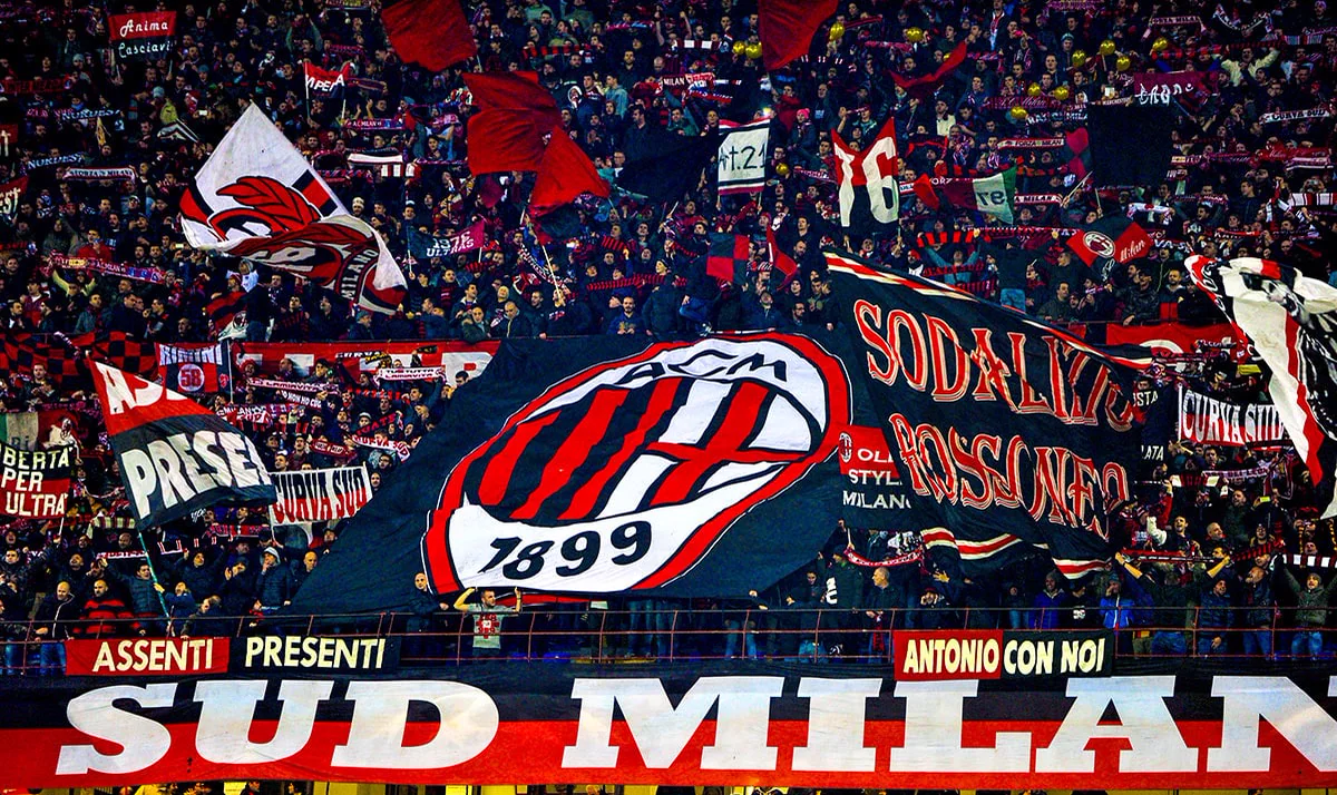 AC Milan-supportrar på Curva Sud med flaggor och klubbmärket