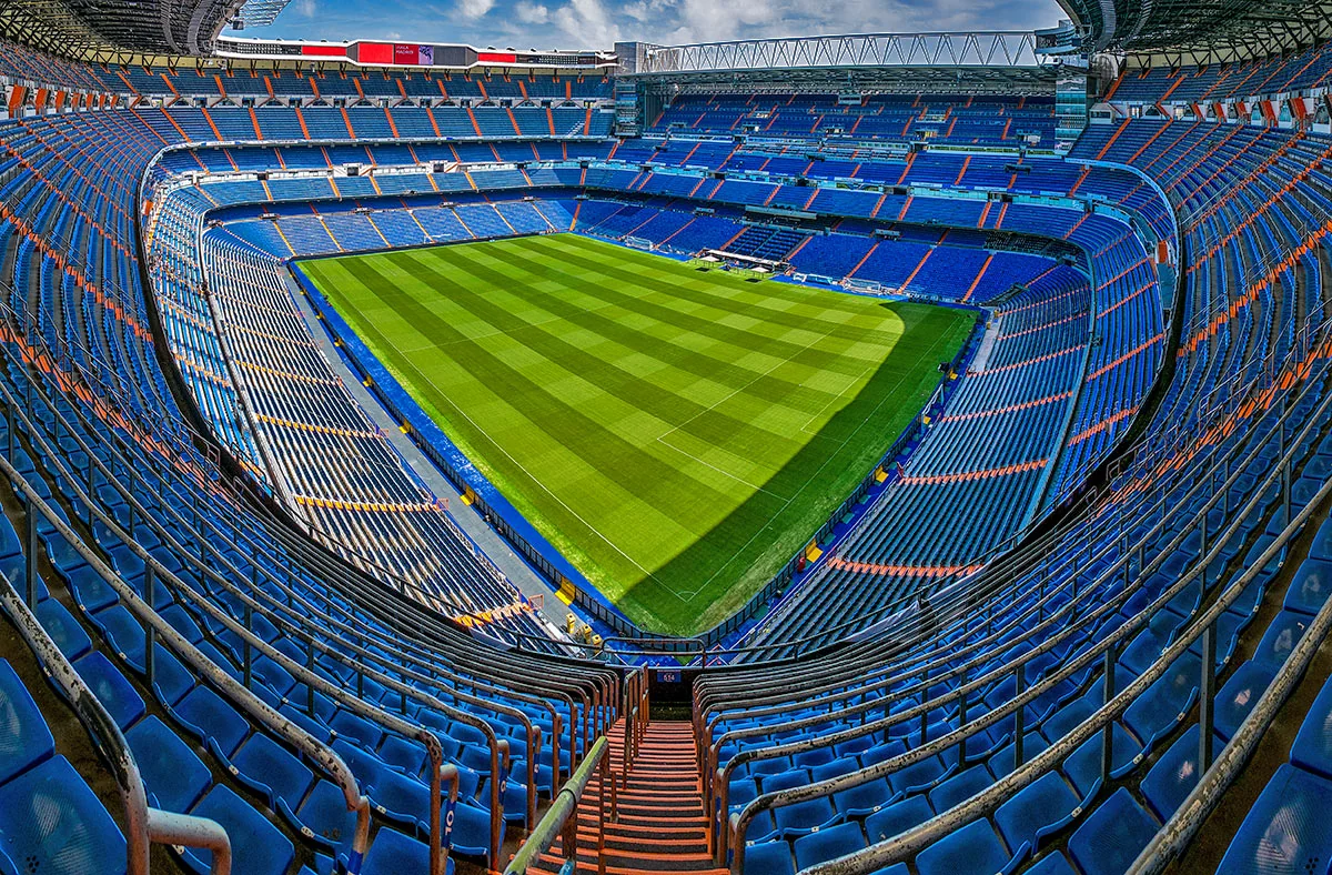 Santiago Bernabéu inifrån med tomma blå läktare runt planen